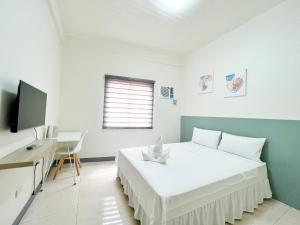 ein Schlafzimmer mit Bett, Schreibtisch und Fernseher in der Unterkunft Verra Inn in Tagaytay