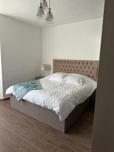 1 dormitorio con 1 cama grande con sábanas blancas en Executive Apartments, en Amán