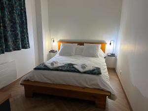 1 dormitorio con 1 cama con 2 toallas en Loft Le Cosy cœur de ville stationnement privatif en Limoges