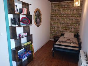 1 dormitorio con cama y estante para libros en Maison Centre d'Hillion, a 300 M de la plage de l'Hôtellerie,jardin clos ,animaux bienvenus en Hillion