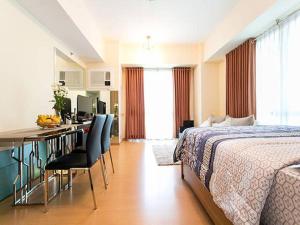 a hotel room with a bed and a desk with chairs at Avant Apartments at The Fort in Manila