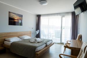 - une chambre avec un lit et une grande fenêtre dans l'établissement Pensjonat Długie Nowicki Rooms & Apartments, à Długie