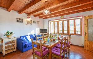 comedor con mesa y sofá azul en 2 Bedroom Lovely Home In Zorzoi, en Sovramonte