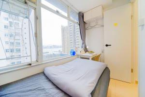 a bed in a room with a large window at Shared Room at Lockhart Road 414 in Hong Kong