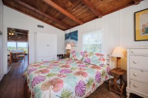 a bedroom with a bed with a colorful comforter at Pounds Cottage, 1 Bedroom, Sleeps 4, Ocean Front, Pet Friendly in Butler Beach