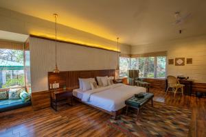 a large bedroom with a large bed and a desk at The Riverwood Forest Retreat - Kanha in Kānha +51 photos