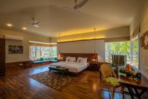 una camera con letto, tavolo e sedie di The Riverwood Forest Retreat - Kanha a Kanha