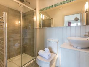 a bathroom with a shower and a toilet and a sink at Westray House in Polzeath