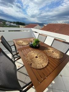 a wooden table with straw umbrellas on a patio at Apartman Roko in Slatine