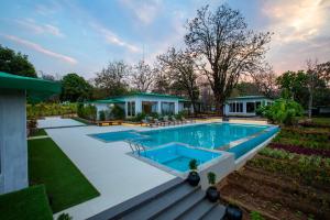 a swimming pool in the backyard of a house at The Riverwood Forest Retreat - Kanha in Kānha