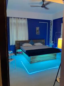 a blue bedroom with a bed with a blue floor at Casa Felice Jonak in Jorhāt