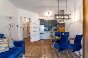 Apart-Invest Apartament Latte في شكلارسكا بوريبا: غرفة معيشة مع أريكة زرقاء وطاولة