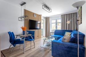 - un salon avec un canapé bleu et une table dans l'établissement Apart-Invest Apartament Latte, à Szklarska Poręba