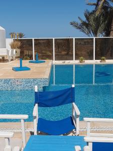 a blue chair sitting next to a swimming pool at Dar Lagune Djerba in Al Ḩaddādah