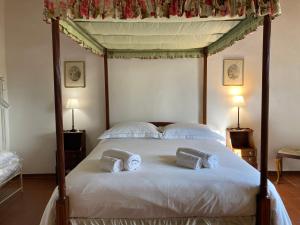 una camera con letto a baldacchino e 2 cuscini sopra di Podere La Paolina a Montefollonico