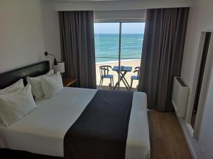 Schlafzimmer mit einem Bett und Meerblick in der Unterkunft Promar - Eco Beach & Spa Hotel in Maceira