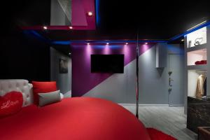 Zimmer mit einem roten Bett und einem TV in der Unterkunft Secret Night II in Toulouse