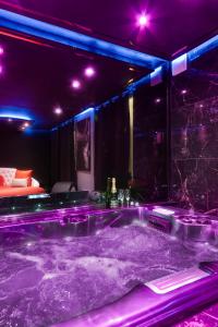 Cette chambre dispose d'une baignoire avec des lumières violettes. dans l'établissement Secret Night II, à Toulouse