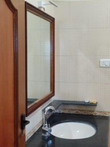 a bathroom with a sink and a mirror at Coralshelters Kochadai in Madurai