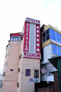 un bâtiment d'hôtel avec un panneau indiquant l'hôtel pour le remboursement dans l'établissement Hotel Mountain View And Rooftop Restaurant, à Pithorāgarh
