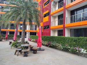 a courtyard with tables and umbrellas in front of a building at Heavenly place 777 on Mai Khao in Ban Mai Salae