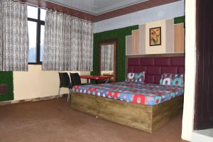 - une chambre avec un lit, une table et des chaises dans l'établissement Hotel Mountain View And Rooftop Restaurant, à Pithorāgarh