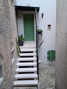 een groene deur op een wit gebouw met een trap bij MONNALISA House in Malcesine