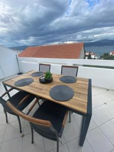 un tavolo in legno e sedie sul balcone. di Apartmani Nika a Slatine