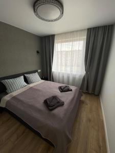 a bedroom with a large bed with a window at ETG Apartment in Mažeikiai