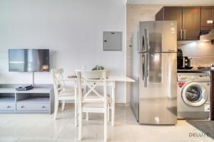 a kitchen with a table and a stainless steel refrigerator at Elegant Studio at Al Madar Siraj Tower 1 Al Barsha South by Deluxe Holiday Homes in Dubai