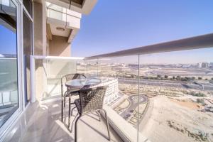 a balcony with a table and chairs on a building at Elegant Studio at Al Madar Siraj Tower 1 Al Barsha South by Deluxe Holiday Homes in Dubai