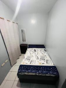 a small bedroom with a bed in a room at Danao LC Bayview in Idanao