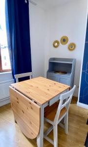 einen Holztisch und Stühle in einem Zimmer mit einem Schreibtisch in der Unterkunft La Vague Dorée - Hyper-Centre - 15 min de Rouen in Barentin