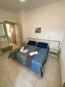 阿祖羅港的住宿－杜托利酒店，一间卧室配有一张大床和两条毛巾