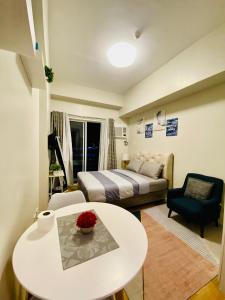 a room with a bed and a table and a couch at Studio unit at The Loop in Cagayan de Oro