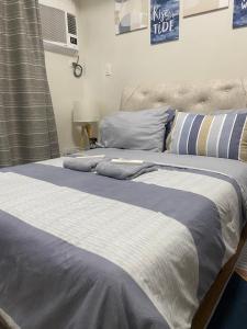 a bed with blue and white blankets and pillows at Studio unit at The Loop in Cagayan de Oro +4 photos