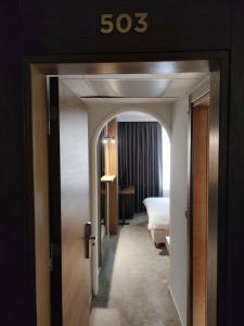 um quarto de hotel com uma cama e uma placa que lê sidx em Oaza Hotel em Stip