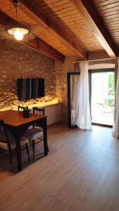 a living room with a table and a large window at Can Barraca in Avinyonet de Puigventós