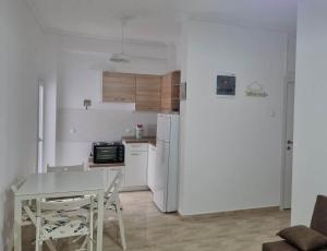 a small kitchen with a table and a refrigerator at N-joy apartment - 3 in Perea +3 photos