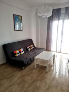 a living room with a black couch and a table at N-joy apartment - 3 in Perea