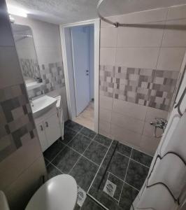 a bathroom with a shower and a toilet and a sink at N-joy apartment - 3 in Perea
