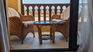 d'une table et de chaises en verre sur le balcon. dans l'établissement Golf Heights Sea and Mountain View Studio with Free Wi-Fi, à Charm el-Cheikh