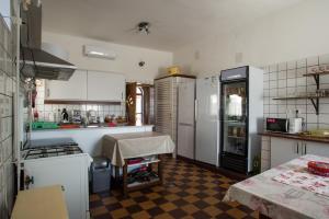 a kitchen with white appliances and a checkered floor at Piros Ponty Panzió in Poroszló