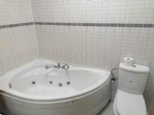 a white bathroom with a tub and a toilet at Šetnja među oblacima in Bajina Bašta