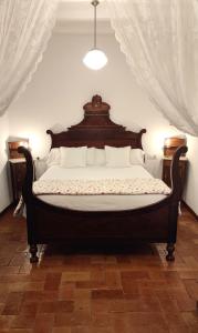 una camera con un grande letto con testiera in legno di Can Barraca ad Avinyonet de Puigventós
