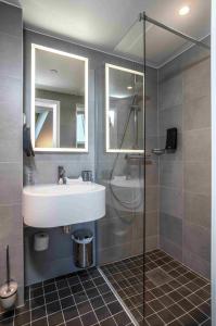 uma casa de banho com um lavatório e um chuveiro em Thon Hotel Ålesund em Ålesund