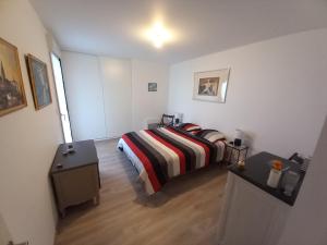 1 dormitorio con 1 cama con manta a rayas en Appartement 4 personnes à Arradon, en Arradon