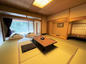 a room with a living room with a table and a room with a room at Sora Togetsusoukinryu in Izu