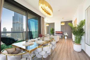 a dining room with a table and chairs in a living room at Magnificent New 3 BR with Stunning View to Burj Khalifa & Fountain view in Dubai