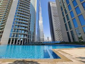 a large swimming pool in a city with the tallest building at Magnificent New 3 BR with Stunning View to Burj Khalifa & Fountain view in Dubai